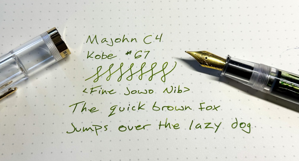 The majohn C4 fountain pen with a writing sample written in green ink